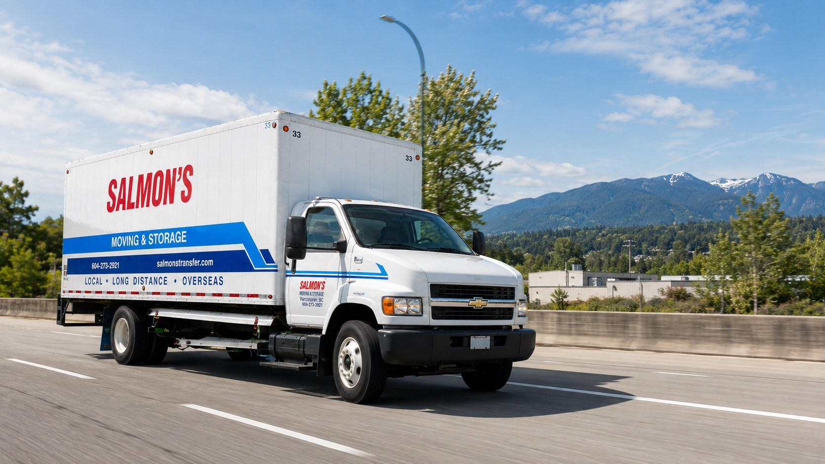 Salmon's Moving & Storage truck driving on a highway near Port Coquitlam, British Columbia with the Coast Mountains behind